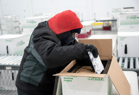 A worker inside the walk-in freezer at McKesson’s Olive Branch, Miss. distribution center adds cold packs into a cooler box of Moderna COVID-19 vaccine doses to maintain their temperature requirements during shipping. (Photo: Business Wire)