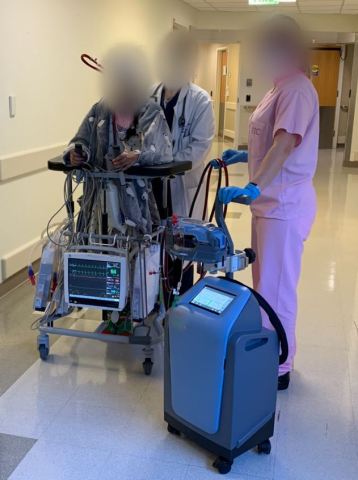 世界で初めてAbiomed Breethe OXY-1 Systemで治療を受けた患者さんがサポートされながら容易に院内を歩き回っている。（写真：ビジネスワイヤ）
