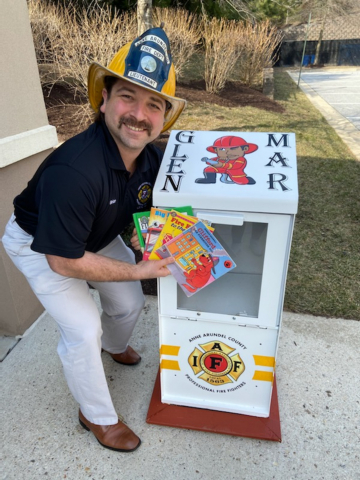 Firefighter-Paramedic Brian Holtslander stands by Glen Mar Apartment Homes' Little Library (Photo: Business Wire)