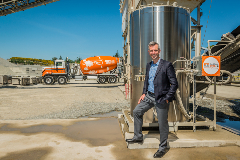 CarbonCure CEO and Founder Rob Niven standing with a CarbonCure system and branded concrete truck (Photo: Business Wire)