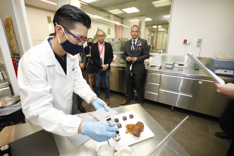 Isaac Goh, Bakery & Confectionery Product Development & Applications Manager South East Asia, gives out tasting samples of melaka (palm sugar) flavored crunchy chocolate cubes to guests on the opening day of ADM's Plant-based Innovation Lab in Singapore. (Photo: Business Wire)
