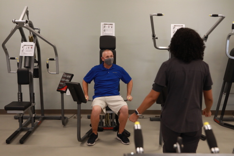 Optum employee demonstrates the new gym equipment during the grand opening event for Optum-Hemet Clinic and Community Center. Credit: Sandy Huffaker