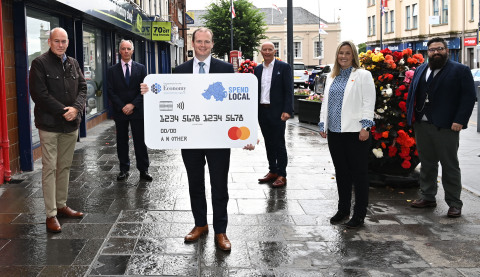 Pictured in Carrickfergus, County Antrim: Far left, Lee Britton, CEO Europe at EML, centre with card, Gordon Lyons, Northern Ireland's Minister for the Economy, and second from right, Sarah Cunningham, Vice President and Lead at Mastercard’s Dublin Technology Hub. (Photo: Business Wire)