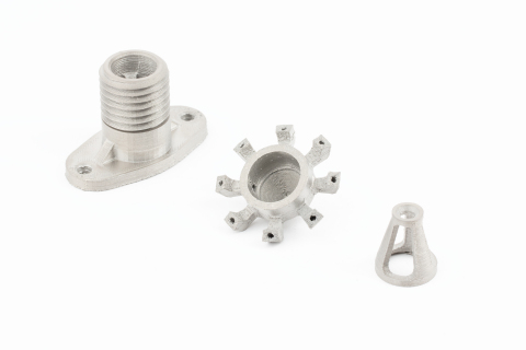 Ti64 parts printed on the Studio System 2 - like this drone coupling, fuel injector nozzle, and telescope focus ring (from left to right) - demonstrate excellent mechanical properties and corrosion resistance on a more accessible platform than legacy powder bed fusion 3D printing alternatives. Tensile properties include 730 MPa yield strength, 845 MPa ultimate tensile strength, and 17 percent elongation. (Photo: Business Wire)