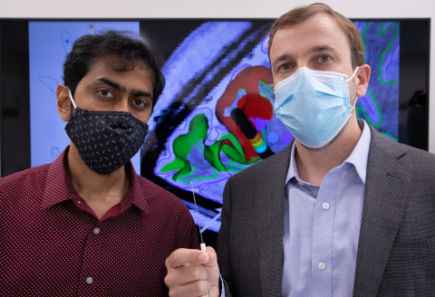 Santosh Chandrasekaran, PhD and Stephan Bickel, MD, PhD, co-lead authors on the paper hold up a SEEG electrode. (Credit: The Feinstein Institutes for Medical Research)