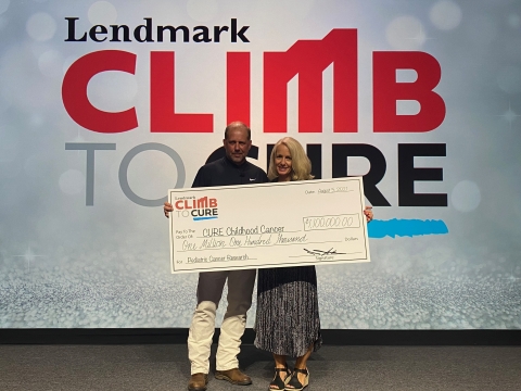 Lendmark Financial Services CEO Bobby Aiken presents $1.1 million in donations to CURE Childhood Cancer CEO Kristin Connor. (Photo: Business Wire)