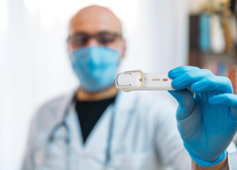 A healthcare provider holding the Lumos FebriDx test. (Photo: Business Wire)