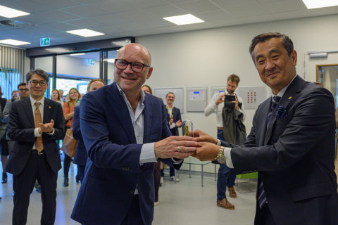 Amito Haarhuis offers Bo Kajiwara a replica of van Leeuwenhoek’s microscope to address the origin and evolution of microscopes for healthcare research (Photo: Business Wire)