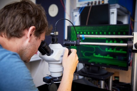 A Toshiba scientist examines a QKD chip under the microscope at the company’s Cambridge Research Laboratory (Photo: Business Wire)
