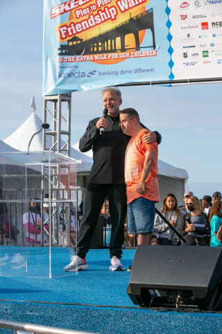 Skechers President Michael Greenberg and Friendship Foundation member Jacob address participants at the 2021 Skechers Pier to Pier Friendship Walk in Manhattan Beach, CA. (Photo: Business Wire)