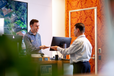 In a Bank of Queensland branch helping a customer  (Photo: Business Wire)