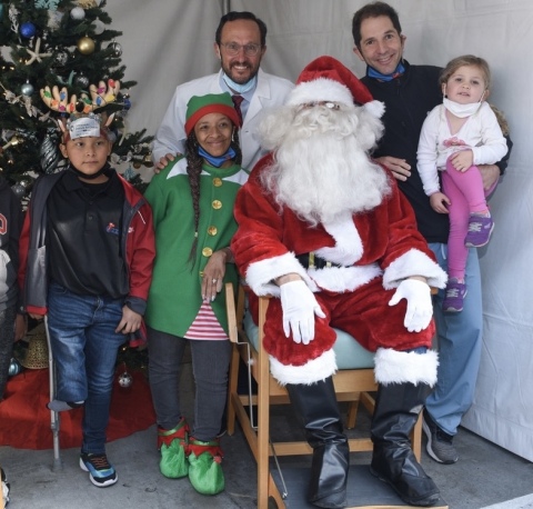 CEO Anthony Scaduto, MD and Nicholas Bernthal, MD, join with Santa to provide holiday cheer to more than 800 underserved children as part of Orthopaedic Institute for Children’s annual “Toys & Joy” celebration in Los Angeles (Photo: Business Wire)