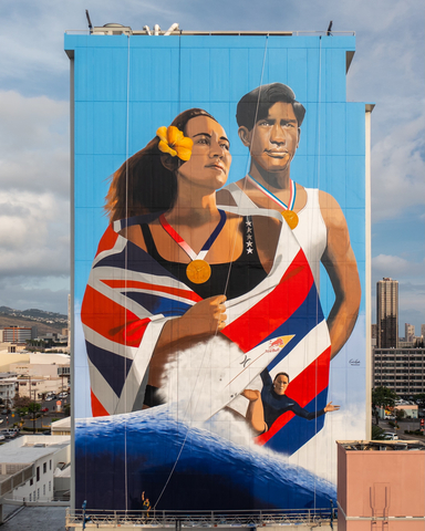 The mural "He‘e Nalu: Two Hawaiian Olympians" was created by artist Kamea Hadar and illustrates dual portraits of Carissa Moore and Duke Kahanamoku. Moore made history by becoming the first women’s Olympic gold medalist in surfing this year as the sport made its debut at the Tokyo 2020 Summer games. Duke Kahanamoku was the first Native Hawaiian Olympian – a two-time silver medalist and three-time gold medalist in swimming – and is also the waterman credited with sharing the sport of surfing across the globe. The massive 100-foot by 60-foot mural depicts both figures proudly wearing their gold medals won over a century apart. The five stars on Moore’s shoulder represent her five world titles in the World Surfing League. Tucked behind her ear she wears the Ilima, or yellow hibiscus, the state flower of Hawaii. At the bottom of the piece is an image of Moore surfing, illustrating her prowess in technical surfing that characterizes the modern-day progression of the sport. (Photo: Business Wire)