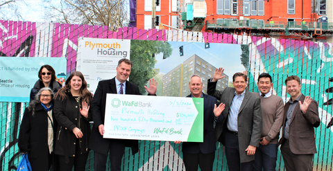 WaFd Bank employees at Plymouth Housing present check to help in their efforts to build 600 Homes for people experiencing homelessness in Seattle and King County, Washington. (Photo: Business Wire)