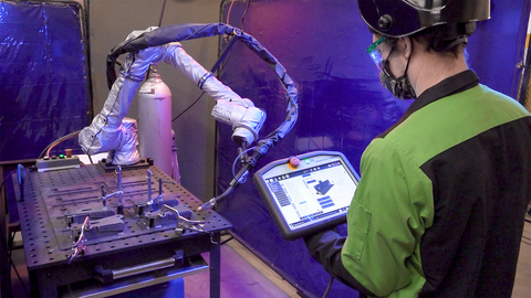 Manufacturing Engineer Austin Laurel programs a collaborative welding robot for automated production of volume parts. (Photo: Lightning eMotors)