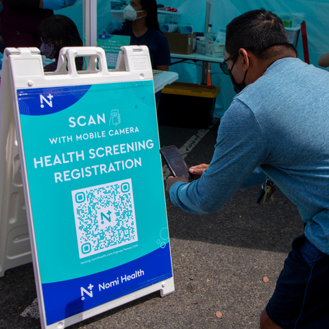 A guest at the Nomi Health Everyday Health Fair held at Waikele Premium Outlets on March 5 captures a QR code to register for free health screenings offered to the community. (Photo: Business Wire)
