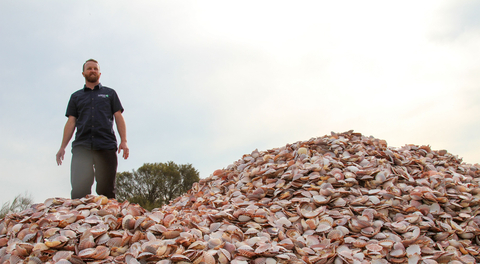 Simon Branigan rides a wave of recycled seashells destined to become bedrock for new shellfish reefs ©Fiona Pepper