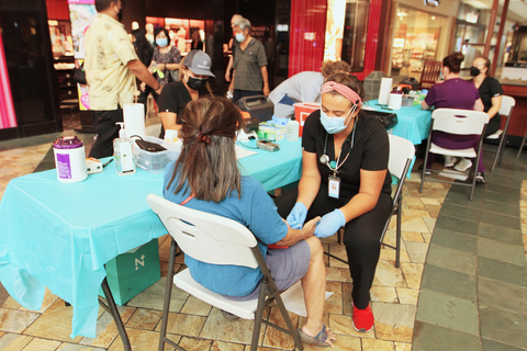 Nomi Health's Jules Finch takes blood from a patient at the company's Community Health Fair at Windward Mall on April 23 where free health screenings were offered to the public. (Photo: Business Wire)