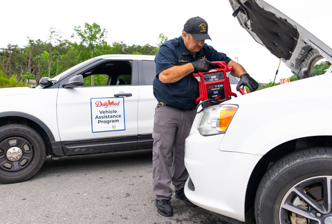 A member of Dollywood's safety and security team assists a park guest by providing a jump start from the Vehicle Assistance Program provided by NAPA AUTO PARTS. (Photo: Business Wire)