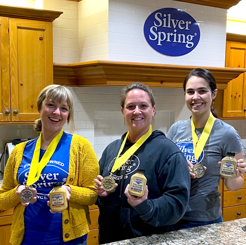 thumbnail Silver Spring Foods Zing Masters holding the 2022 World-Wide Mustard Competition winning mustards (from left to right: Sarah Kolk, Judy Christensen, Victoria Neuman) (Photo: Business Wire)