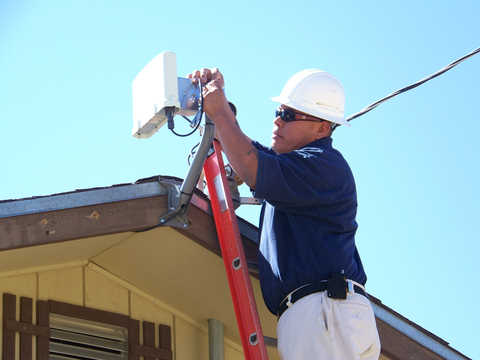 Sacred Wind employee installs fixed wireless home internet. (Photo: Business Wire)
