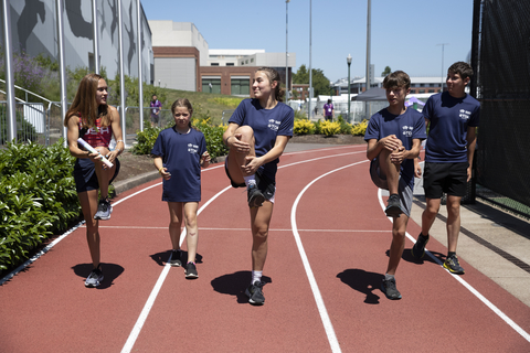 Team USA athlete Sinclaire Johnson guides young participants through their pre-race exercises. (Photo: Business Wire)