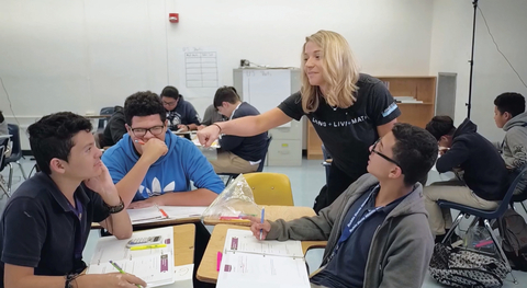 A middle school math instructor celebrates an aha! moment with a student using Carnegie Learning’s MATHbook, a component of the Middle School Math Solution that earned perfect scores from EdReports. Photo courtesy Carnegie Learning.