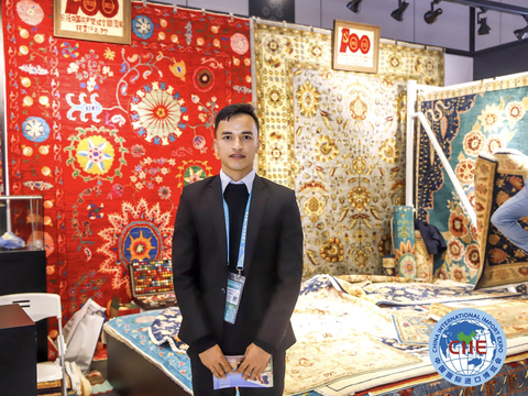 An exhibitor stands in front of the handmade wool carpets displayed at the fourth China International Import Expo held in Shanghai from Nov 5-10, 2021. (Photo: Business Wire)
