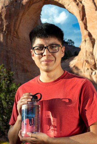 Diné designer Jaden Redhair holds the new Nalgene Water Fund “Tó éí iiná” (Water is Life) limited-edition bottle he created for Nalgene Outdoor to help combat the water crisis on the Navajo Nation (Photo: Business Wire)