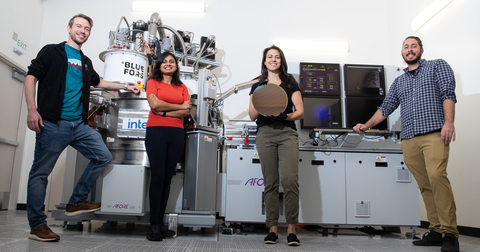 Intel quantum engineers Florian Luthi (from left), Aditi Nethwewala, Stephanie Bojarski and Otto Zietz stand in front of a van-sized tool called a cryoprober, which sits in a lab at Gordon Moore Park at Ronler Acres in Oregon. In the cryoprober’s chamber, 300-millimeter silicon wafers are tested at 1.7 kelvins, just above absolute zero. Bojarski holds one of those 300-millimeter spin qubit wafers. (Credit: Intel Corporation)