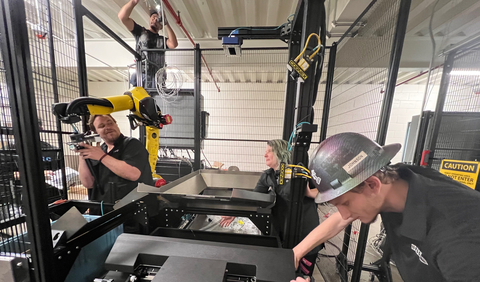Working with a FANUC robot and a Pregis automated bagging machine, OSARO staff members collaborate with NPSG Global technicians to construct OSARO® Robotic Bagging System cells at Zenni Optical in Novato, California. (Photo: Business Wire)