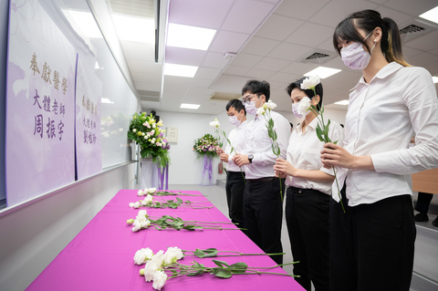 Students of the Post-baccalaureate Program in Medicine at NTHU offering Chinese bellflowers to those who have donated their cadavers to the program. (Photo: National Tsing Hua University)