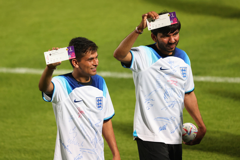 Two men pose with England vs. Iran match tickets, produced by HID, during a community event at Al Wakrah Stadium on November 17, 2022 in Doha, Qatar. (Photo by Marc Atkins/Getty Images)