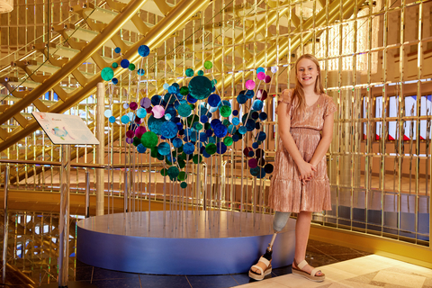 St. Jude patient Bridget with a new sculpture inspired by her art on Carnival Cruise Line’s latest ship. (Photo: Business Wire)