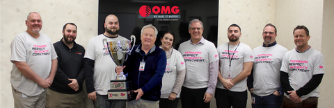 original OMG Inc. President Hubert McGovern (holding cup) takes photo with employees who received sponsorships to coach local youth. (Photo: Business Wire)
