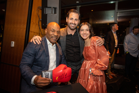 Mike Tyson (left), Dave Cantin, Executive Chairman and CEO (center), and Valentina Nejfelt celebrate the auctioning of autographed boxing gloves at Dave Cantin Group’s event on behalf of DCG Giving. Photo credit: Matt Carroll, Colossus Media Group