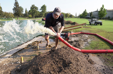 Ecological Improvements Erosion Specialist, Michael Frick, washing sediment into Bioengineered Living Shoreline Containment System (Photo: Business Wire)