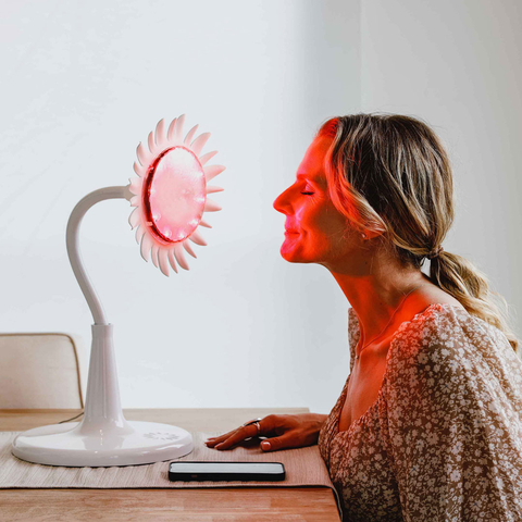 Woman pictured utilizing Sunflower Smart Light Therapy™ lamp's skin routine to stimulate collagen production. (Photo: Business Wire)
