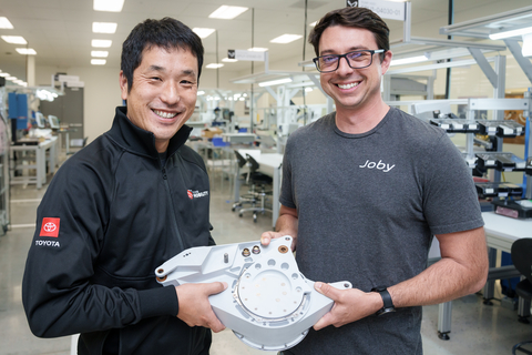 Kazuhiro Sato (left) and Jordi Gischler (right) present a completed tilt actuator, manufactured at Joby’s San Carlos production facility with key parts supplied by Toyota. (Photo: Joby Aviation)