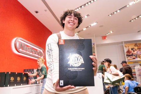 In this photo provided by Nintendo of America, David C. from New Jersey poses with his official copy of The Legend of Zelda: Tears of the Kingdom following the game’s midnight launch at the Nintendo NY Store in Rockefeller Plaza. The Legend of Zelda: Tears of the Kingdom for Nintendo Switch is available now and a direct sequel to The Legend of Zelda: Breath of the Wild, where players decide their own path through the sprawling landscapes of Hyrule and discover new destinations, dangers, sights and puzzles that require wits and resourcefulness to overcome. (Photo: Business Wire)