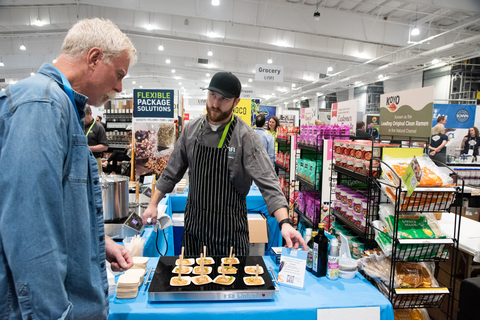 original Customer learning about new product at UNFI’s Annual Natural Holiday Show. (Photo: Business Wire)