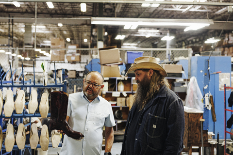 thumbnail Chris Stapleton admires The San Antonio in Black Cherry at Lucchese's El Paso factory. (Photo: Business Wire)