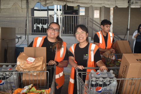 Volunteers distribute food for Meals with Meaning milestone event. (Photo: Business Wire)