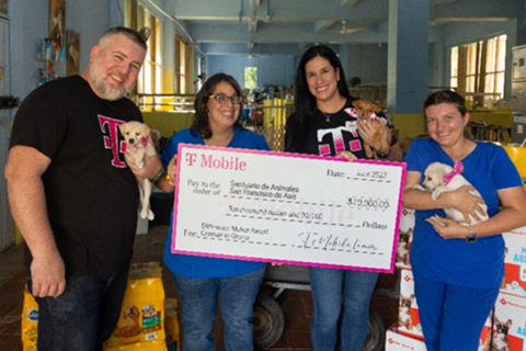 T-Mobile employees visited the organizations to deliver the news and to make the donations. In this photo: Nelson Vélez and María Ojeda from the San Germán T-Mobile store visited San Francisco de Asís Animal Sanctuary, bringing food and cleaning supplies as well as two hotspots to support their office operation. Dellymar Bernal and Esmeralda Montalvo (along with some cheerful furry residents) celebrated their visit. (Photo: Business Wire)