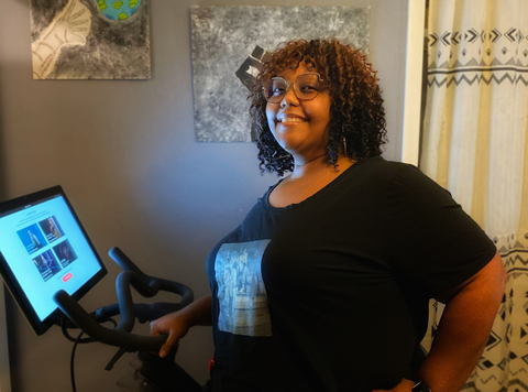 Corvias Property Management Leasing Consultant, Andrea Ruffin poses with the indoor bike she received for participating in Wellness@Corvias. (Photo: Business Wire)