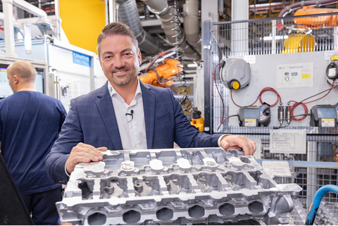 Eric Bader, Managing Director of ExOne, a Desktop Metal Company, stands behind a cylinder head that was produced with the help of a 6-cylinder water jacket core that was binder jet 3D printed on the ExOne Exerial system. (Photo: Business Wire)