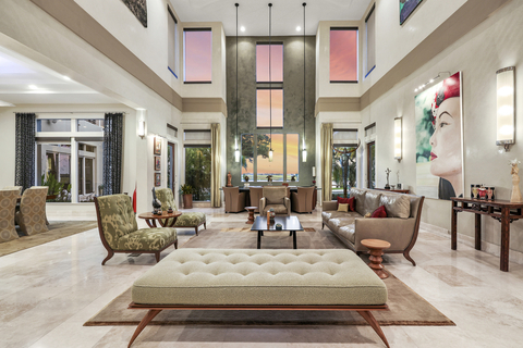 A blend of modern and contemporary design defines the home’s interiors. Shown here: the grand salon, featuring two-story ceilings, a waterside wet bar and plenty of room for art display. WaterfrontLuxuryAuction.com. (Photo: Business Wire)