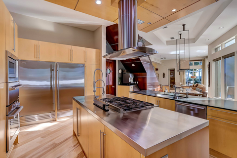 As functional as it is sleek, the kitchen offers high-end appliances, custom cabinetry, and a wall of windows with water views. One of two dining areas is immediately adjacent to the kitchen. Learn more at WaterfrontLuxuryAuction.com. (Photo: Business Wire)