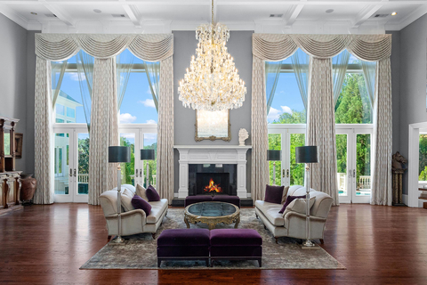 A lovely grand salon is at the center of the home. Two-story ceilings and floor-to-ceiling windows fill the space will natural light, while four sets of French doors lead to the oversized patio and pool. GALuxuryAuction.com. (Photo: Business Wire)
