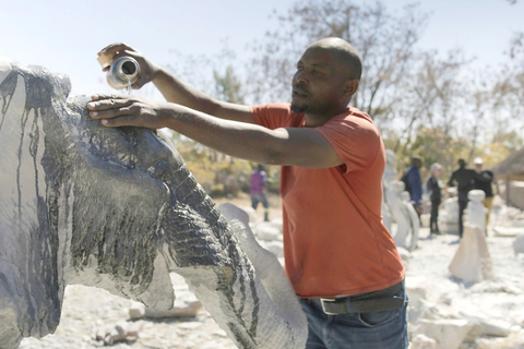 An artist uses clean water to finish an art installation. Kalahari Resorts provided the resources to bring a reliable clean water source to Chitungwiza Art Center in Zimbabwe. Artists use the water to sculpt awe-inspiring pieces that provide a source of income for the community. (Photo: Business Wire)